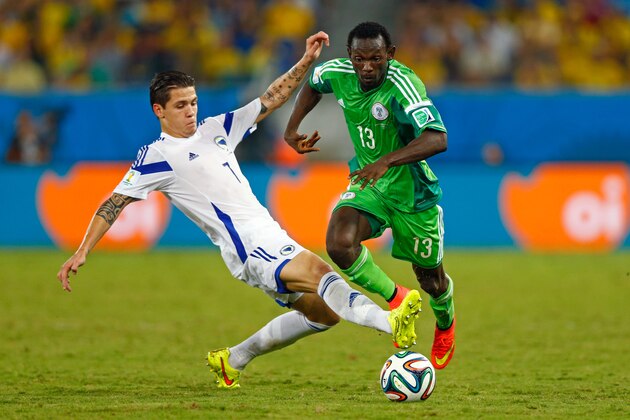 CUIABA, BRAZIL - JUNE 21:  Muhamed Besic of Bosnia and Herzegovina tackles Juwon Oshaniwa during the 2014 FIFA World Cup Group F match between Nigeria and Bosnia-Herzegovina at Arena Pantanal on June 21, 2014 in Cuiaba, Brazil.  (Photo by Phil Walter/Getty Images)