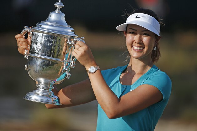 Michelle Wie pass with the trophy after winning the U.S. Women's Open golf tournament in Pinehurst, N.C., Sunday, June 22, 2014. (AP Photo/John Bazemore)