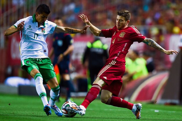 SEVILLE, SPAIN - MAY 30:  Alberto Moreno of Spain competes for the ball with Juan Carlos Arce of Bolivia an international friendly match between Spain and Bolivia at Estadio Ramon Sanchez Pizjuan on May 30, 2014 in Seville, Spain.  (Photo by David Ramos/Getty Images)