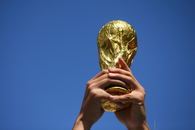 SAO PAULO, BRAZIL - JUNE 23:  A fan holds up a replica of the World Cup trophy prior to the 2014 FIFA World Cup Brazil Group B match between the Netherlands and Chile at Arena de Sao Paulo on June 23, 2014 in Sao Paulo, Brazil.  (Photo by Julian Finney/Getty Images)