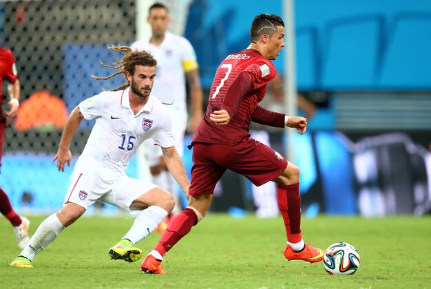 Jun 22, 2014; Manaus, Amazonas, BRAZIL; Portugal forward Cristiano Ronaldo (7) controls the ball against USA midfielder Kyle Beckerman (15) during the 2014 World Cup at Arena Amazonia. The game ended in a 2-2 draw.  Mandatory Credit: Mark J. Rebilas-USA TODAY Sports