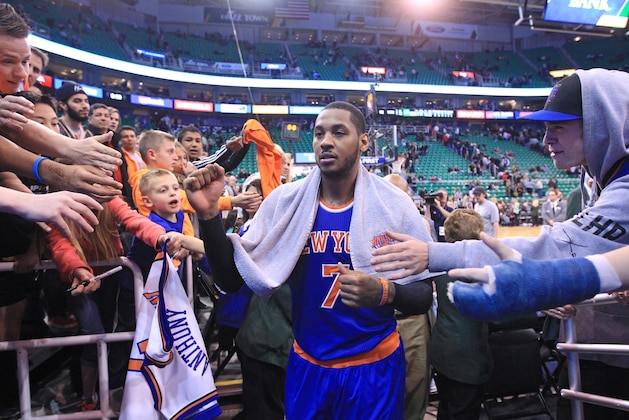 Fans reach for New York Knicks' Carmelo Anthony (7) as he walks off the court following their NBA basketball game against the Utah Jazz Monday, March 31, 2014, in Salt Lake City. The Knicks won 92-83. (AP Photo/Rick Bowmer)