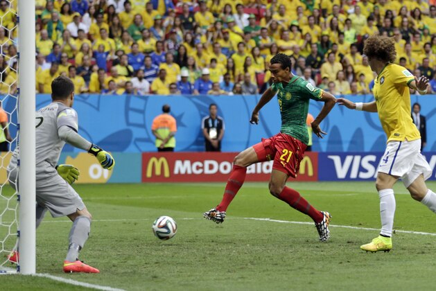 Cameroon's Joel Matip, center, scores his side's first goal during the group A World Cup soccer match between Cameroon and Brazil at the Estadio Nacional in Brasilia, Brazil, Monday, June 23, 2014. (AP Photo/Dolores Ochoa)