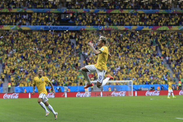 Brazil's Neymar leaps in the air to celebrate after scoring his side's second goal during the group A World Cup soccer match between Cameroon and Brazil at the Estadio Nacional in Brasilia, Brazil, Monday, June 23, 2014. (AP Photo/Bernat Armangue)