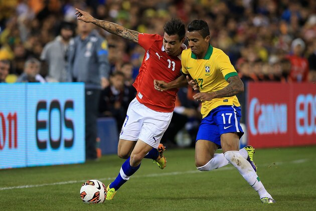 TORONTO, ON - NOVEMBER 19:  Eduardo Vargas #11 of Chile carries the ball up field as Luiz Gustavo #17 of Brazil defends during a friendly match at Rogers Centre on November 19, 2013 in Toronto, Canada.  (Photo by Dave Sandford/Getty Images)