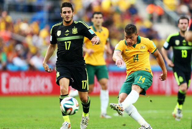 CURITIBA, BRAZIL - JUNE 23: James Troisi of Australia strikes the ball against Koke of Spain during the 2014 FIFA World Cup Brazil Group B match between Australia and Spain at Arena da Baixada on June 23, 2014 in Curitiba, Brazil.  (Photo by Jeff Gross/Getty Images)