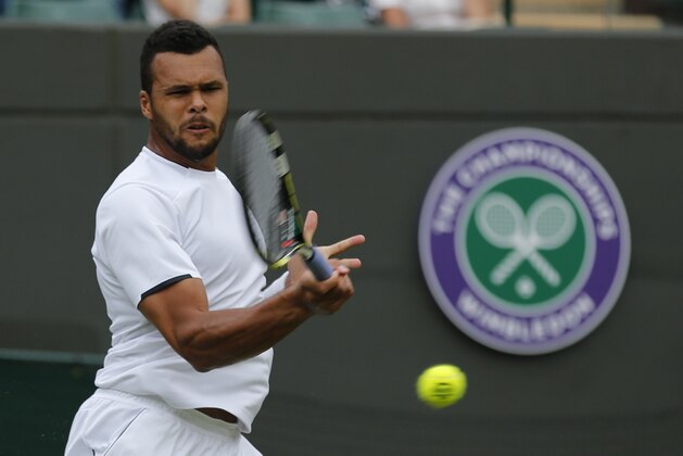 Jo-Wilfried Tsonga of France plays a return to  Juergen Melzer of Austria during their first round match at the All England Lawn Tennis Championships in Wimbledon, London, Monday, June 23, 2014. (AP Photo/Ben Curtis)