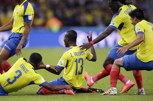 Ecuador's Enner Valencia, center, celebrates with teammates after scoring his team's second goal during the group E World Cup soccer match between Honduras and Ecuador at the Arena da Baixada in Curitiba, Brazil, Friday, June 20, 2014.  (AP Photo/Michael Sohn)