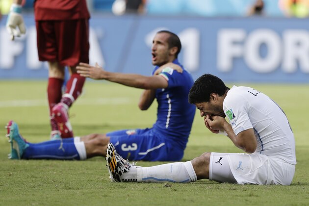 Italy's Giorgio Chiellini complains after Uruguay's Luis Suarez ran into his shoulder with his teeth during the group D World Cup soccer match between Italy and Uruguay at the Arena das Dunas in Natal, Brazil, Tuesday, June 24, 2014. (AP Photo/Ricardo Mazalan)
