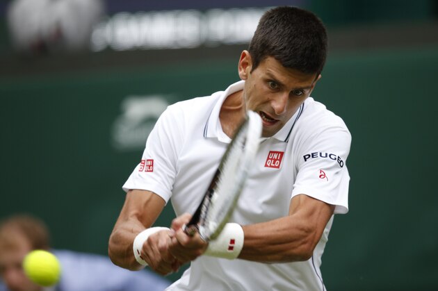 Novak Djokovic of Serbia plays a return to Andrey Golubev of Kazakhstan during their first round match at the All England Lawn Tennis Championships in Wimbledon, London,  Monday, June  23, 2014. (AP Photo/Pavel Golovkin)