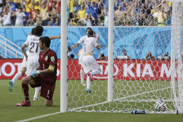 Italy's goalkeeper Gianluigi Buffon kneels outside his goal after being scored on by Uruguay's Diego Godin (3) during the group D World Cup soccer match between Italy and Uruguay at the Arena das Dunas in Natal, Brazil, Tuesday, June 24, 2014. Uruguary defeated Italy 1-0. (AP Photo/Ricardo Mazalan)