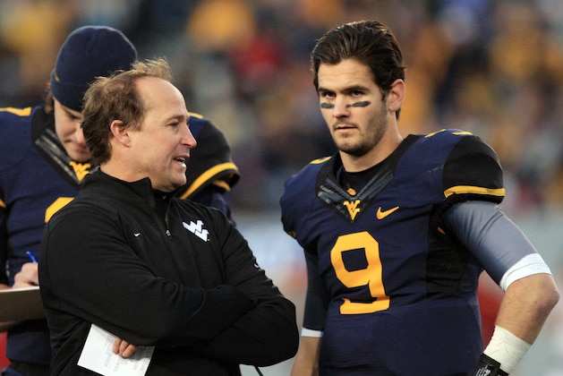West Virginia coach Dana Holgorsen speaks with quarterback Clint Trickett (9) during a timeout in the second quarter of their NCAA college football game against Iowa State in Morgantown, W.Va., on Saturday, Nov. 30, 2013. (AP Photo/Christopher Jackson)