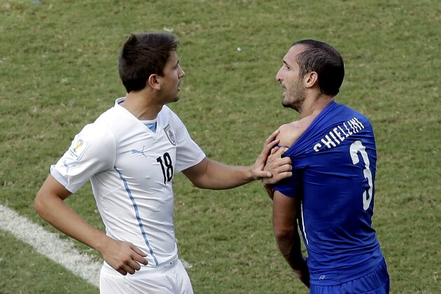 Italy's Giorgio Chiellini (3) complains after Uruguay's Luis Suarez ran into his shoulder with his teeth during the group D World Cup soccer match between Italy and Uruguay at the Arena das Dunas in Natal, Brazil, Tuesday, June 24, 2014. (AP Photo/Hassan Ammar)