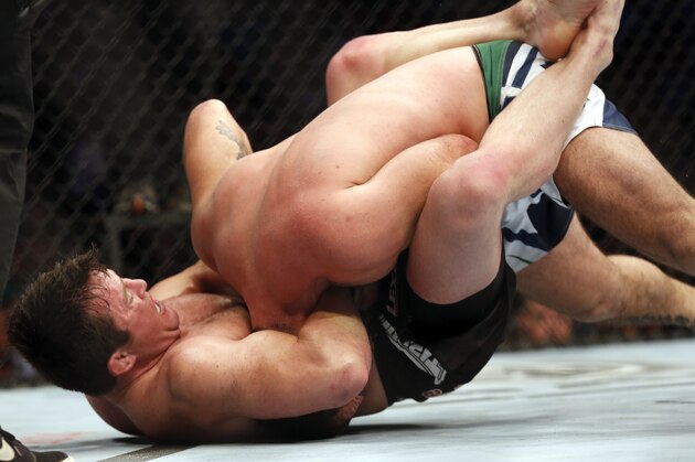 Chael Sonnen, left, sinks in the fight-winning choke against Mauricio 'Shogun' Rua, of Brazil, during their UFC on Fox Sports 1 mixed martial arts light heavyweight bout in Boston, Saturday, Aug. 17,2013.  Sonnen won via first round tapout via guillotine choke. (AP Photo/Gregory Payan)