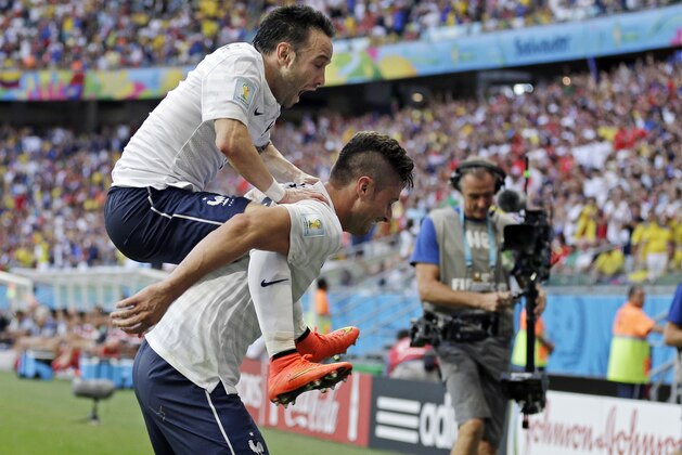 France's Mathieu Valbuena (8) jumps on Olivier Giroud's back after scoring his side's third goal during the group E World Cup soccer match between Switzerland and France at the Arena Fonte Nova in Salvador, Brazil, Friday, June 20, 2014. Giroud scored France's first goal. (AP Photo/Natacha Pisarenko)