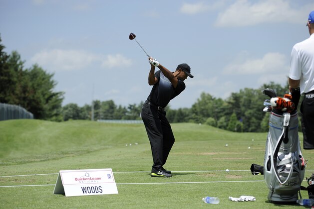 Tiger Woods gets set to swing at the driving range as he practices at the Quicken Loans National golf tournament, Tuesday, June 24, 2014, in Bethesda, Md. (AP Photo/Nick Wass)