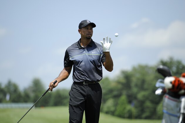 Tiger Woods catches a ball at the driving range as he practices at the Quicken Loans National golf tournament, Tuesday, June 24, 2014, in Bethesda, Md. (AP Photo/Nick Wass)