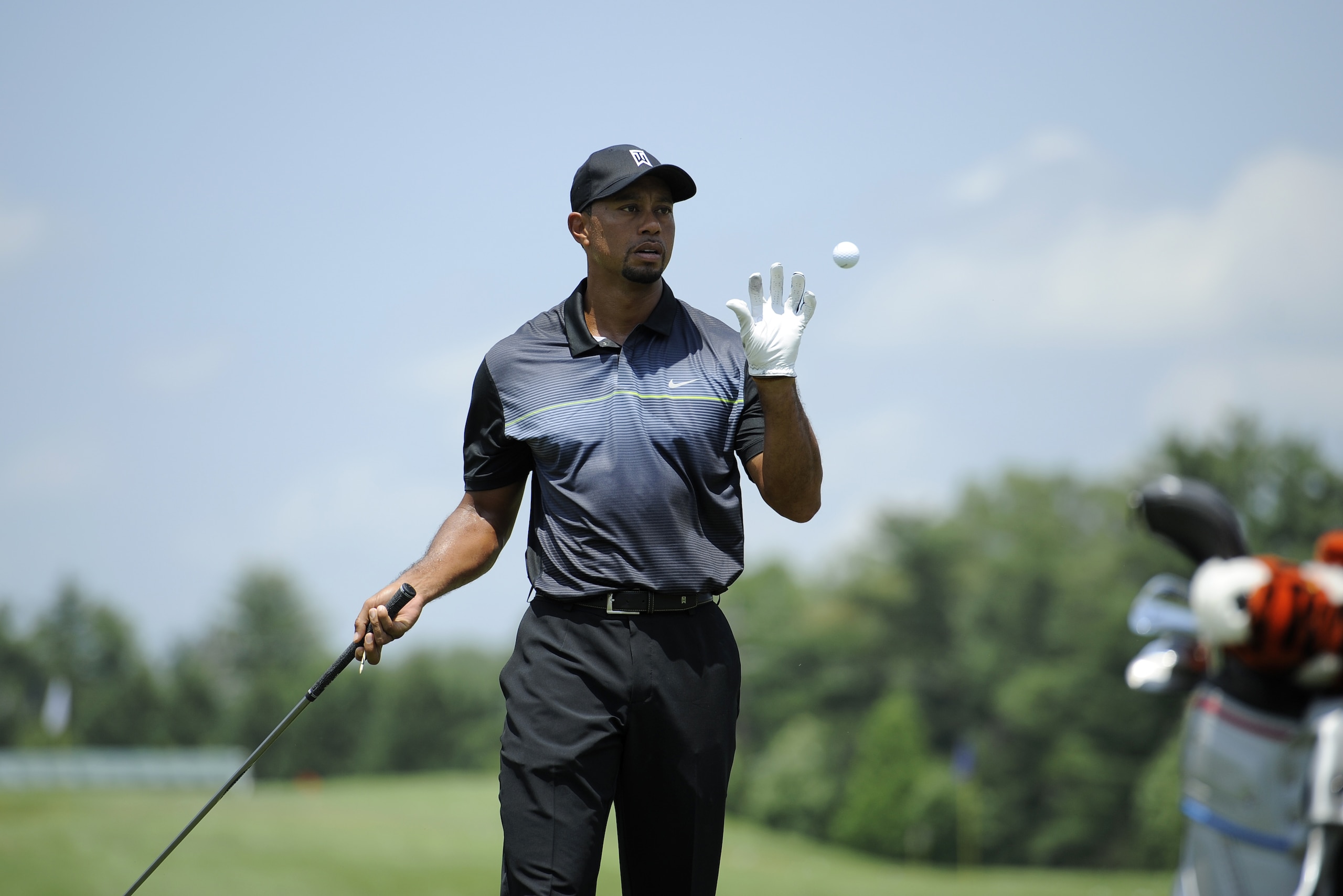Tiger Woods catches a ball at the driving range as he practices at the Quicken Loans National golf tournament, Tuesday, June 24, 2014, in Bethesda, Md. (AP Photo/Nick Wass)
