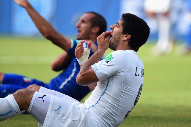 NATAL, BRAZIL - JUNE 24:  Luis Suarez of Uruguay and Giorgio Chiellini of Italy react after a clash during the 2014 FIFA World Cup Brazil Group D match between Italy and Uruguay at Estadio das Dunas on June 24, 2014 in Natal, Brazil.  (Photo by Matthias Hangst/Getty Images)