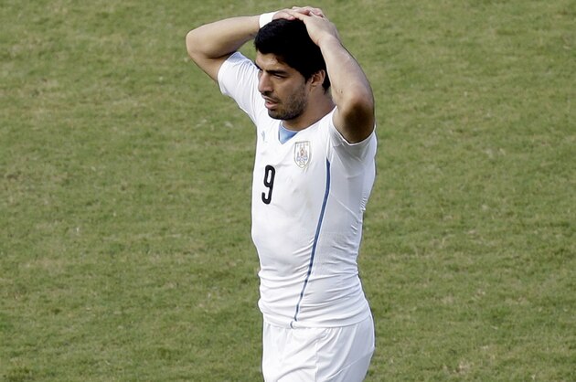 Uruguay's Luis Suarez walks with his hands on his head during the group D World Cup soccer match between Italy and Uruguay at the Arena das Dunas in Natal, Brazil, Tuesday, June 24, 2014. (AP Photo/Hassan Ammar)