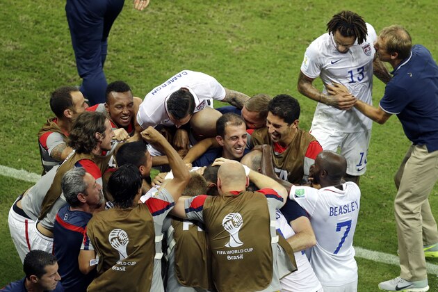 United States' head coach Juergen Klinsmann, right, briefs Jermaine Jones as their team celebrates scoring their second goal during the group G World Cup soccer match between the USA and Portugal at the Arena da Amazonia in Manaus, Brazil, Sunday, June 22, 2014. The match ended in a 2-2 draw. (AP Photo/Themba Hadebe)