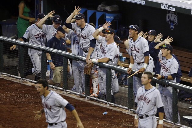 Players in the Virginia dugout celebrate after Virginia's Brandon Downes hit an RBI triple in the sixth inning of Game 2 of the best-of-three NCAA baseball College World Series finals against Vanderbilt in Omaha, Neb., Tuesday, June 24, 2014. (AP Photo/Nati Harnik)