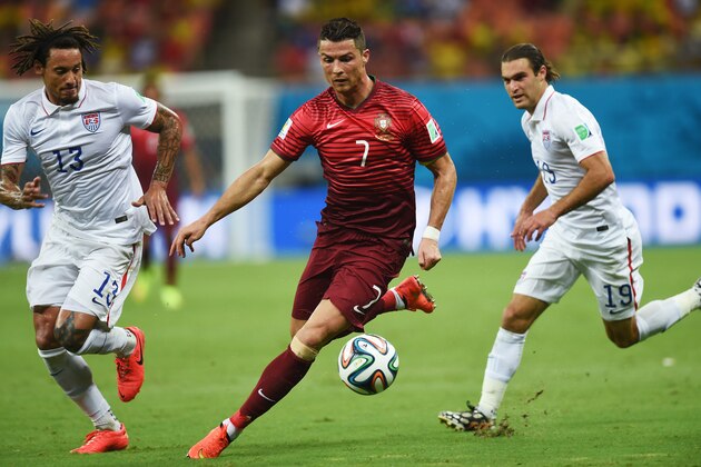 Portugal's Cristiano Ronaldo, center, runs with the ball between United States' Jermaine Jones, left, and United States' Graham Zusi, right, during the group G World Cup soccer match between the USA and Portugal at the Arena da Amazonia in Manaus, Brazil, Sunday, June 22, 2014. (AP Photo/Paulo Duarte)