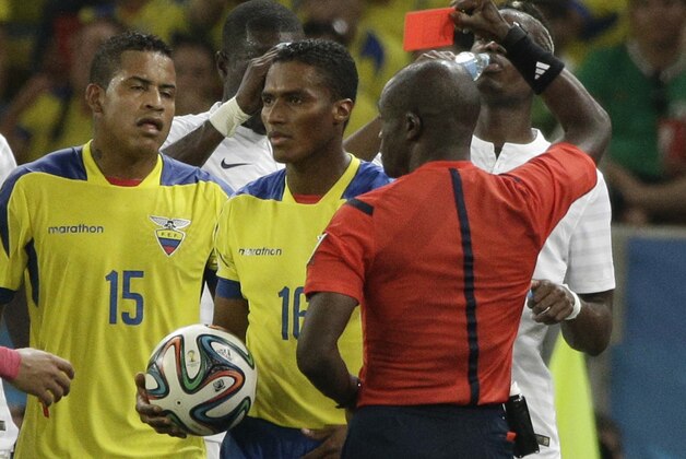 Ecuador's Antonio Valencia, center, is awarded a red card by referee Noumandiez Doue from the Ivory Coast, right, during the group E World Cup soccer match between Ecuador and France at the Maracana Stadium in Rio de Janeiro, Brazil, Wednesday, June 25, 2014. (AP Photo/Christophe Ena)