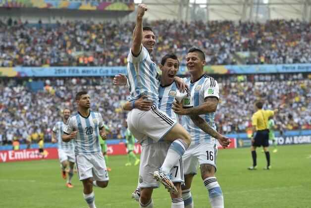 Argentina's Lionel Messi, left, is carried by his teammates Argentina's Angel di Maria (7) and Argentina's Marcos Rojo after scoring his side's first goal during the group F World Cup soccer match between Nigeria and Argentina at the Estadio Beira-Rio in Porto Alegre, Brazil, Wednesday, June 25, 2014. (AP Photo/Martin Meissner)