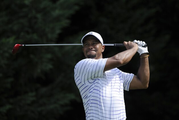 Tiger Woods watches his tee shot on the fifth tee during the opening ceremony Pro-Am at the Quicken Loans National golf tournament, Wednesday, June 25, 2014, in Bethesda, Md. (AP Photo/Nick Wass)