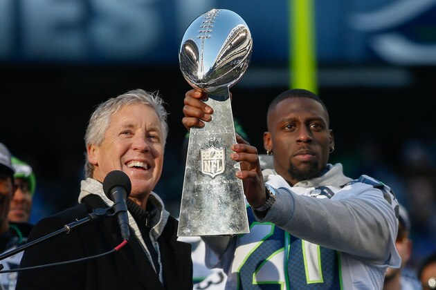 SEATTLE, WA - FEBRUARY 05:  Head coach Pete Carroll of the Seattle Seahawks (L) looks on as running back Jeremy Lane #20 holds the Lombardi Trophy during ceremonies following the Super Bowl XLVIII Victory Parade at CenturyLink Field on February 5, 2014 in Seattle, Washington.  (Photo by Otto Greule Jr/Getty Images)