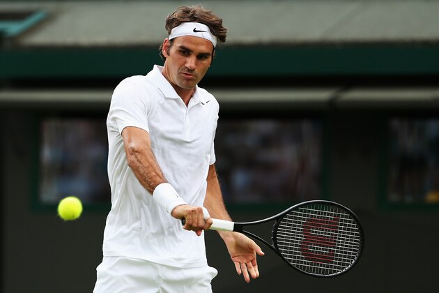LONDON, ENGLAND - JUNE 24:  Roger Federer of Switzerland plays a backhand during his Gentlemen's Singles first round match against Paolo Lorenzi of Italy on day two of the Wimbledon Lawn Tennis Championships at the All England Lawn Tennis and Croquet Club at Wimbledon on June 24, 2014 in London, England.  (Photo by Jan Kruger/Getty Images)