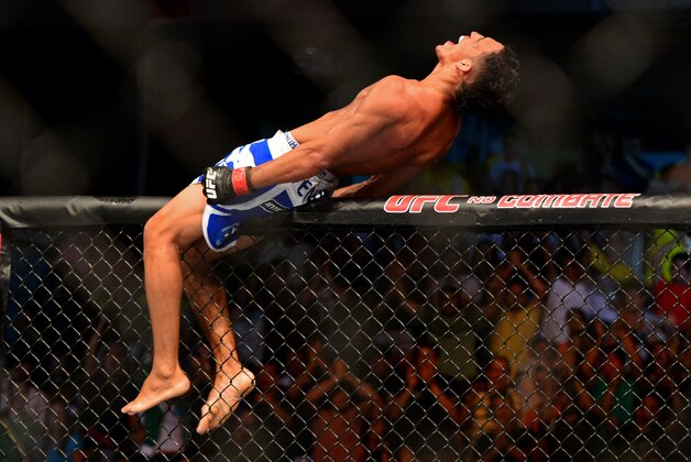 Feb 15, 2014; Jaragua do Sul, SC, Brazil; Charles Oliveira (red gloves) reacts after defeating Andy Ogle (blue gloves) during UFC Fight Night Machida vs Mousasi at Arena Jaragua. Mandatory Credit: Jason Silva-USA TODAY Sports