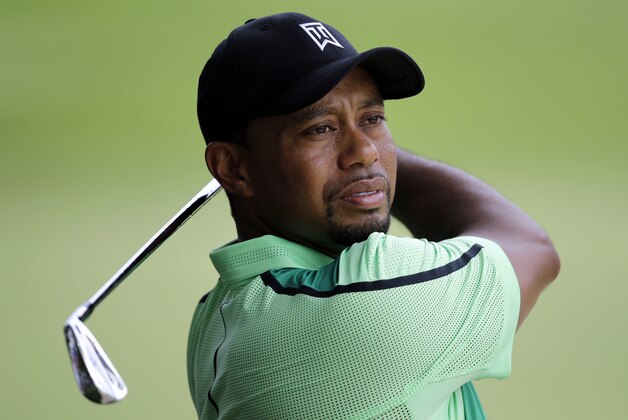 Tiger Woods takes a practice swing before hitting out of a sand trap on the ninth fairway during the first round of the Quicken Loans National PGA golf tournament, Thursday, June 26, 2014, in Bethesda, Md. (AP Photo/Patrick Semansky)