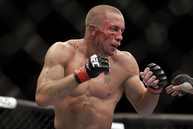 Georges St. Pierre, of Canada, fights Johny Hendricks during a UFC 167 mixed martial arts championship welterweight bout on Saturday, Nov. 16, 2013, in Las Vegas. St. Pierre won by split decision. (AP Photo/Isaac Brekken)