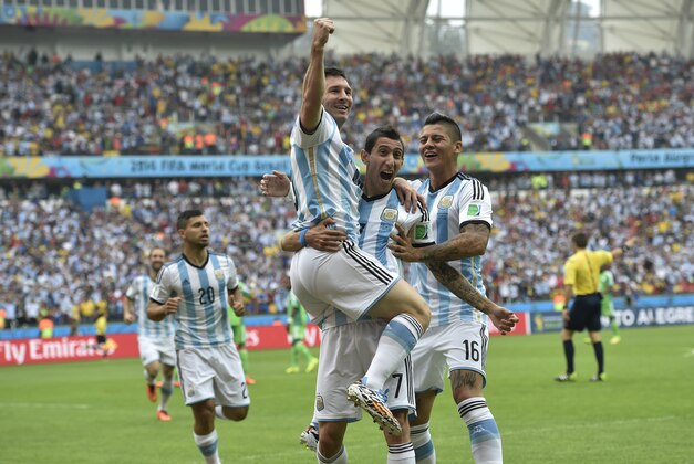Argentina's Lionel Messi, left, is carried by his teammates Argentina's Angel di Maria (7) and Argentina's Marcos Rojo after scoring his side's first goal during the group F World Cup soccer match between Nigeria and Argentina at the Estadio Beira-Rio in Porto Alegre, Brazil, Wednesday, June 25, 2014. (AP Photo/Martin Meissner)