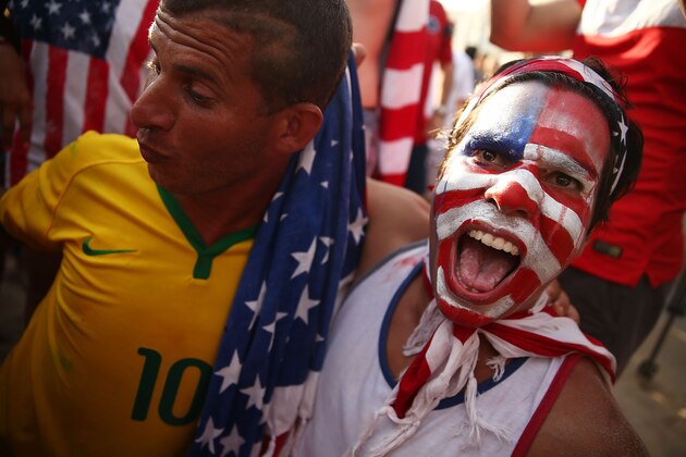 RIO DE JANEIRO, BRAZIL - JUNE 26:  A U.S. supporter and a Brazil supporter celebrate the U.S. advancing to the Round of 16 after their loss to Germany while watching the match at FIFA Fan Fest on June 26, 2014 in Rio de Janeiro, Brazil. The U.S. lost 1-0 but still advance to the knockout stage of the 2014 FIFA World Cup based on goal differential.  (Photo by Mario Tama/Getty Images)