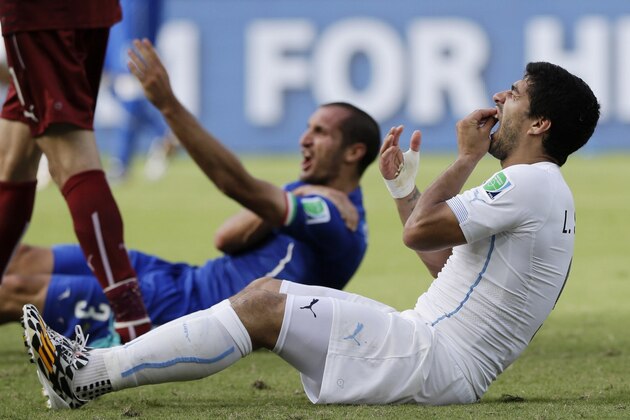 FILE - In this June 24, 2014 file photo, Uruguay's Luis Suarez holds his teeth after biting Italy's Giorgio Chiellini's shoulder during the group D World Cup soccer match between Italy and Uruguay at the Arena das Dunas in Natal, Brazil. On Thursday, June 26, 2014, FIFA banned Suarez for 9 games and 4 months for biting his opponent at the World Cup. (AP Photo/Ricardo Mazalan, File)