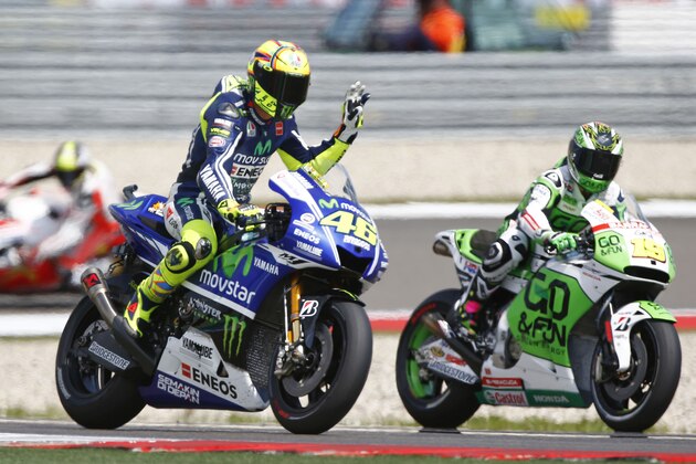 Valentino Rossi of Italy, left, gestures on his Yamaha during the second MotoGP Free Practice of the Dutch Grand Prix, in Assen, northern Netherlands, Thursday June 26,2014. (AP Photo/Vincent Jannink)