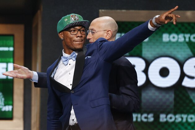 Oklahoma State's Marcus Smart, left, points to fans after being selected sixth overall by the Boston Celtics during the 2014 NBA draft, Thursday, June 26, 2014, in New York. (AP Photo/Jason DeCrow)
