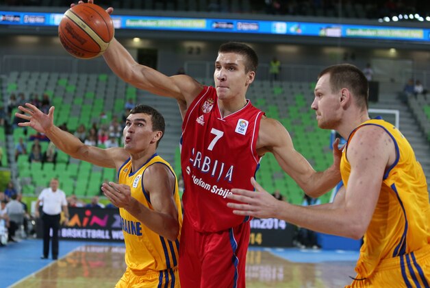 Ukraine's Maksym Pustozvonov, left, with Ihor Zaytsev, right, and Serbia's Bogdan Bogdanovic go of the ball during a EuroBasket European Basketball Championship Group E match at the Stozice Arena, in Ljubljana, Slovenia, Friday, Sept. 13, 2013. (AP Photo/Thanassis Stavrakis)