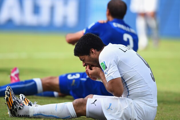 NATAL, BRAZIL - JUNE 24:  Luis Suarez of Uruguay and Giorgio Chiellini of Italy react after a clash during the 2014 FIFA World Cup Brazil Group D match between Italy and Uruguay at Estadio das Dunas on June 24, 2014 in Natal, Brazil.  (Photo by Matthias Hangst/Getty Images)