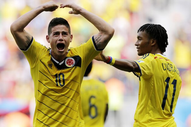 Colombia's James Rodriguez (10) celebrates with teammate Colombia's Juan Cuadrado after scoring his side's first goal during the group C World Cup soccer match between Colombia and Ivory Coast at the Estadio Nacional in Brasilia, Brazil, Thursday, June 19, 2014. (AP Photo/Fernando Llano)
