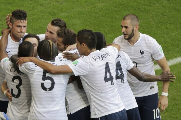 Members of the French soccer team group around Mathieu Valbuena as they celebrate after he scored their third goal during the group E World Cup soccer match between Switzerland and France at the Arena Fonte Nova in Salvador, Brazil, Friday, June 20, 2014. (AP Photo/Sergei Grits)