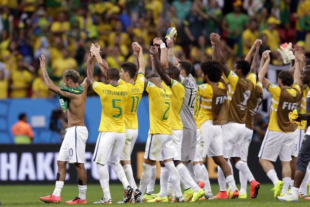 Brazil's Neymar, left, celebrates with his teammates after  a 4-1 win over Cameroon during the group A World Cup soccer match between Cameroon and Brazil at the Estadio Nacional in Brasilia, Brazil, Monday, June 23, 2014. (AP Photo/Dolores Ochoa)