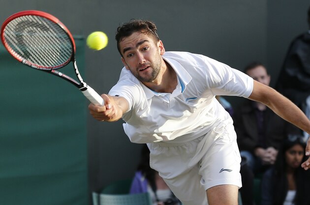 Marin Cilic of Croatia plays a return to Tomas Berdych of Czech Republic during their men's singles match at the All England Lawn Tennis Championships in Wimbledon, London, Friday June 27, 2014. (AP Photo/Ben Curtis)