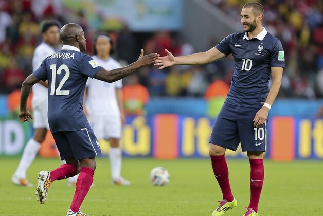 France's Karim Benzema, right, celebrates with France's Rio Mavuba after scoring his side's third goal during the group E World Cup soccer match between France and Honduras at the Estadio Beira-Rio in Porto Alegre, Brazil, Sunday, June 15, 2014. (AP Photo/David Vincent)