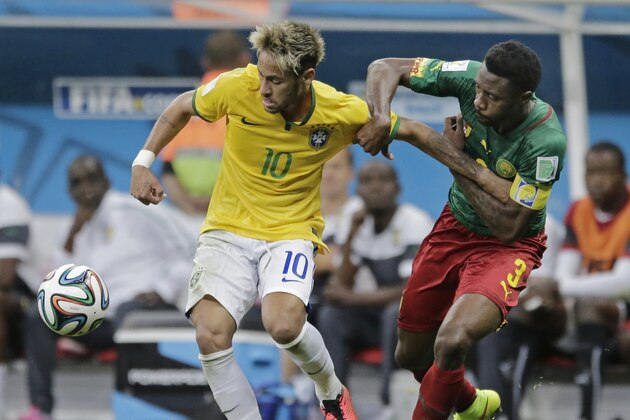 Cameroon's Nicolas N’Koulou holds Brazil's Neymar during the group A World Cup soccer match between Cameroon and Brazil at the Estadio Nacional in Brasilia, Brazil, Monday, June 23, 2014. (AP Photo/Bernat Armangue)