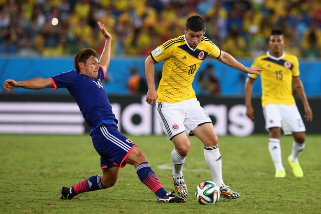 CUIABA, BRAZIL - JUNE 24:  Toshihiro Aoyama of Japan tackles James Rodriguez of Colombia during the 2014 FIFA World Cup Brazil Group C match between Japan and Colombia at Arena Pantanal on June 24, 2014 in Cuiaba, Brazil.  (Photo by Adam Pretty/Getty Images)