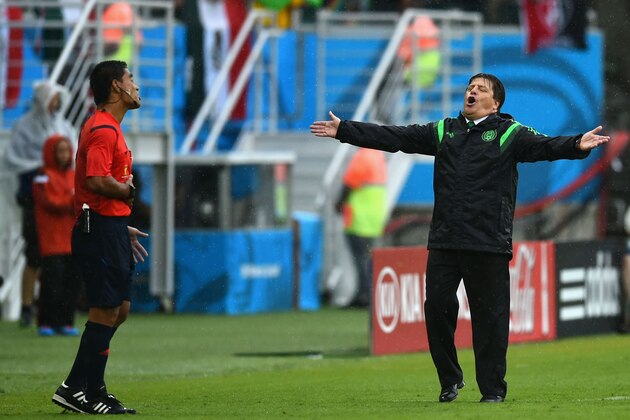 NATAL, BRAZIL - JUNE 13: Head coach Miguel Herrera of Mexico reacts toward fourth official Norbert Hauata during the 2014 FIFA World Cup Brazil Group A match between Mexico and Cameroon at Estadio das Dunas on June 13, 2014 in Natal, Brazil.  (Photo by Matthias Hangst/Getty Images)